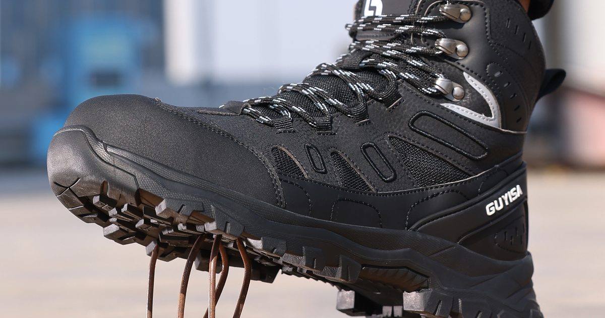 Safety boot with a deep-lug outsole stepping onto nails in a puncture test